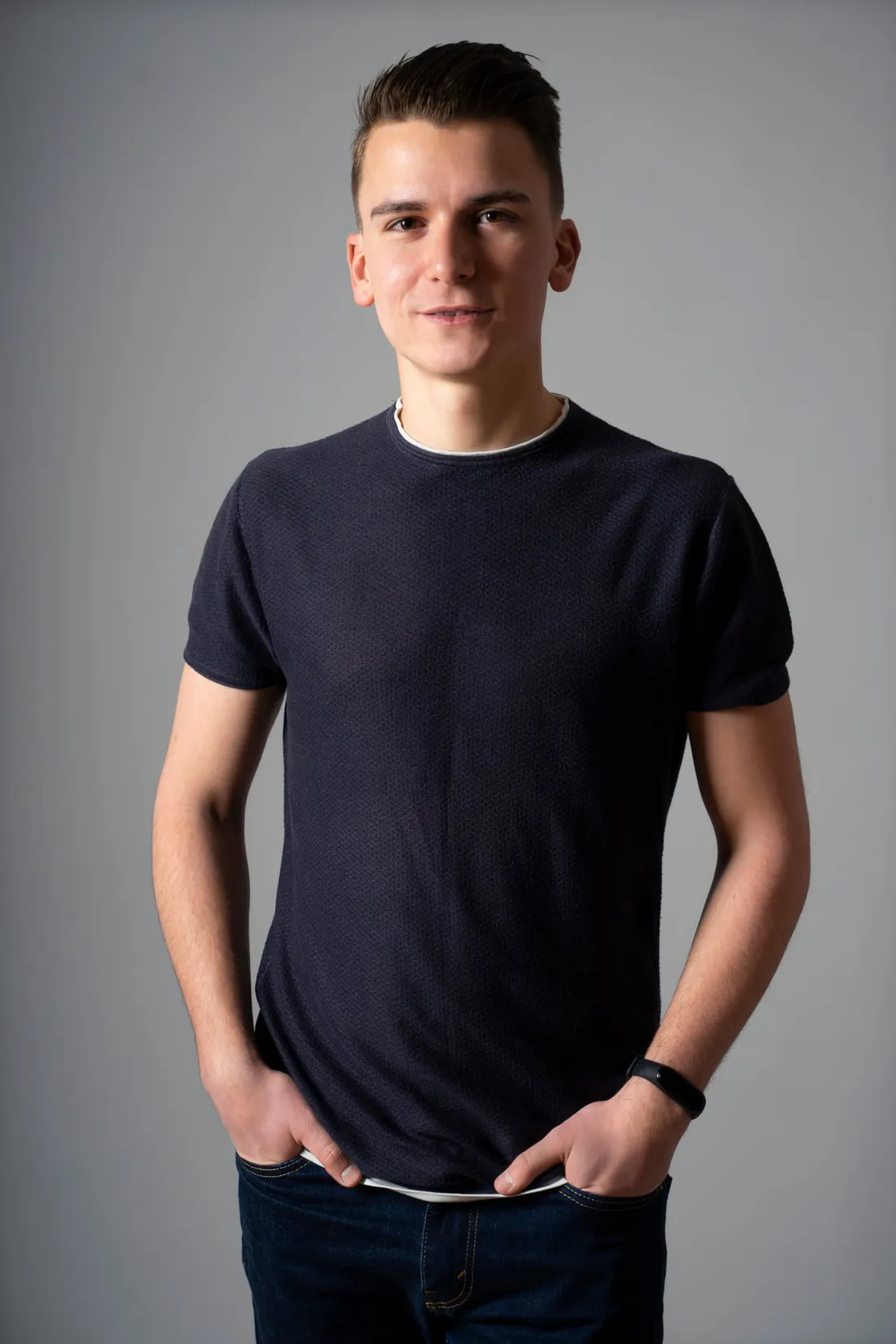 Andrzej Siedlecki standing in a grey studio